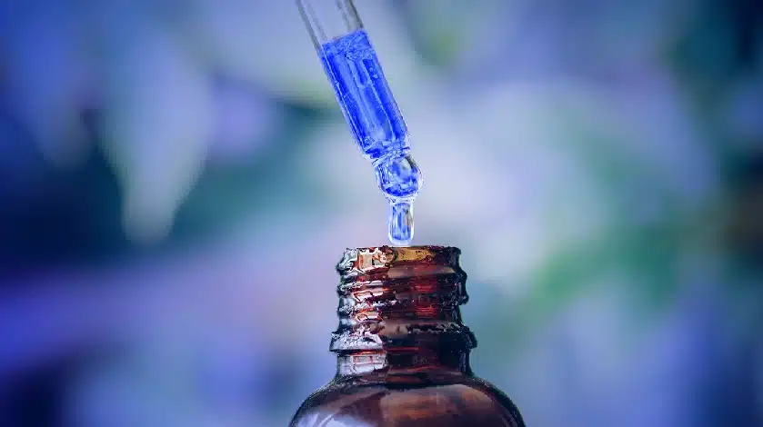 A blue liquid is being poured into a bottle.